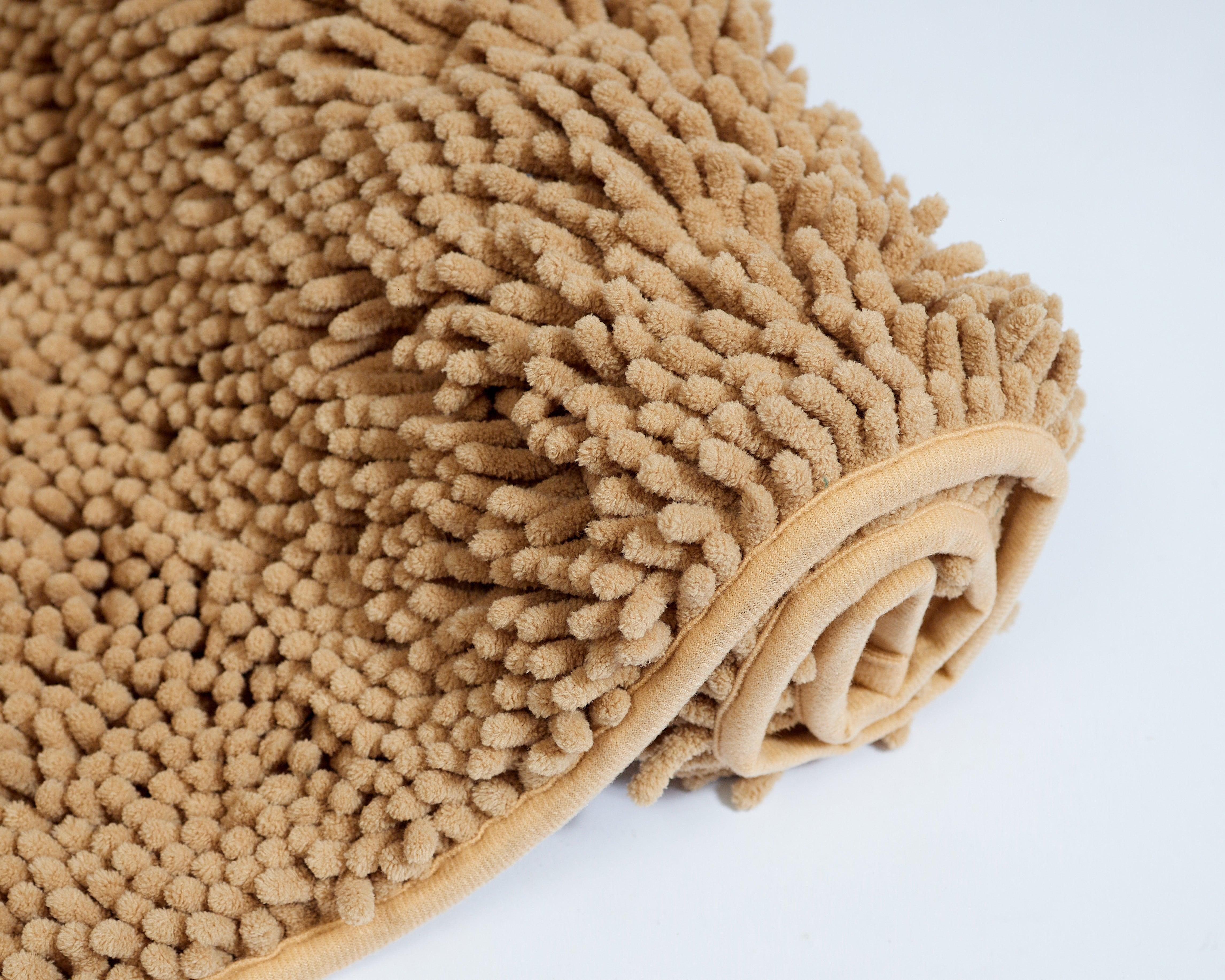 Mily Bath Rug in beige, soft plush texture, rolled up.