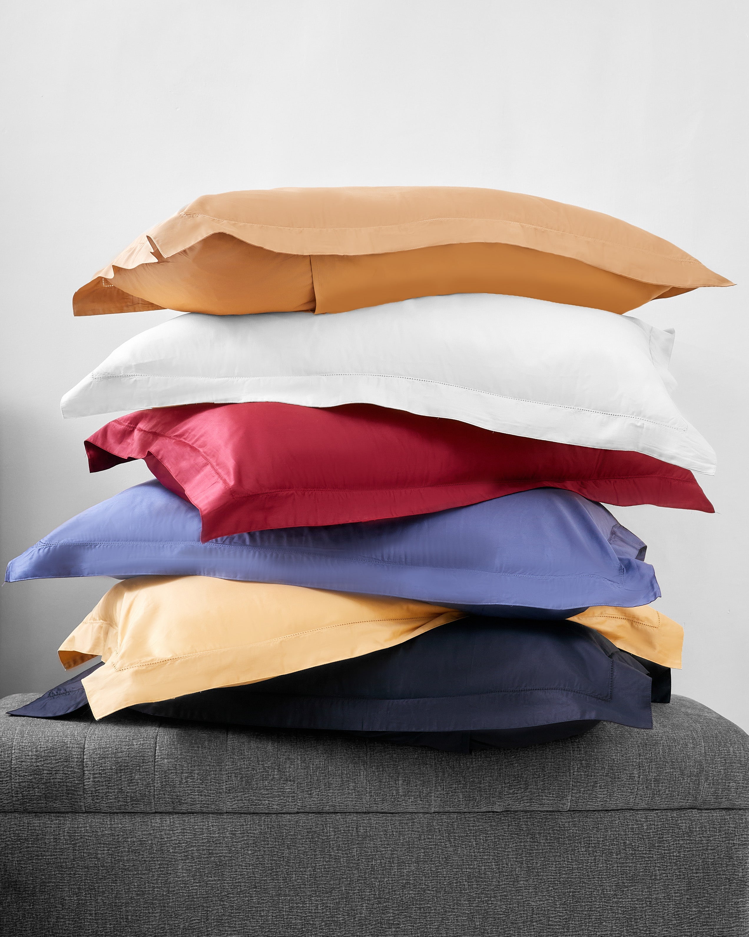 Reserve 6pc Bedding Collection with colorful hemstitch cotton pillowcases stacked on grey surface