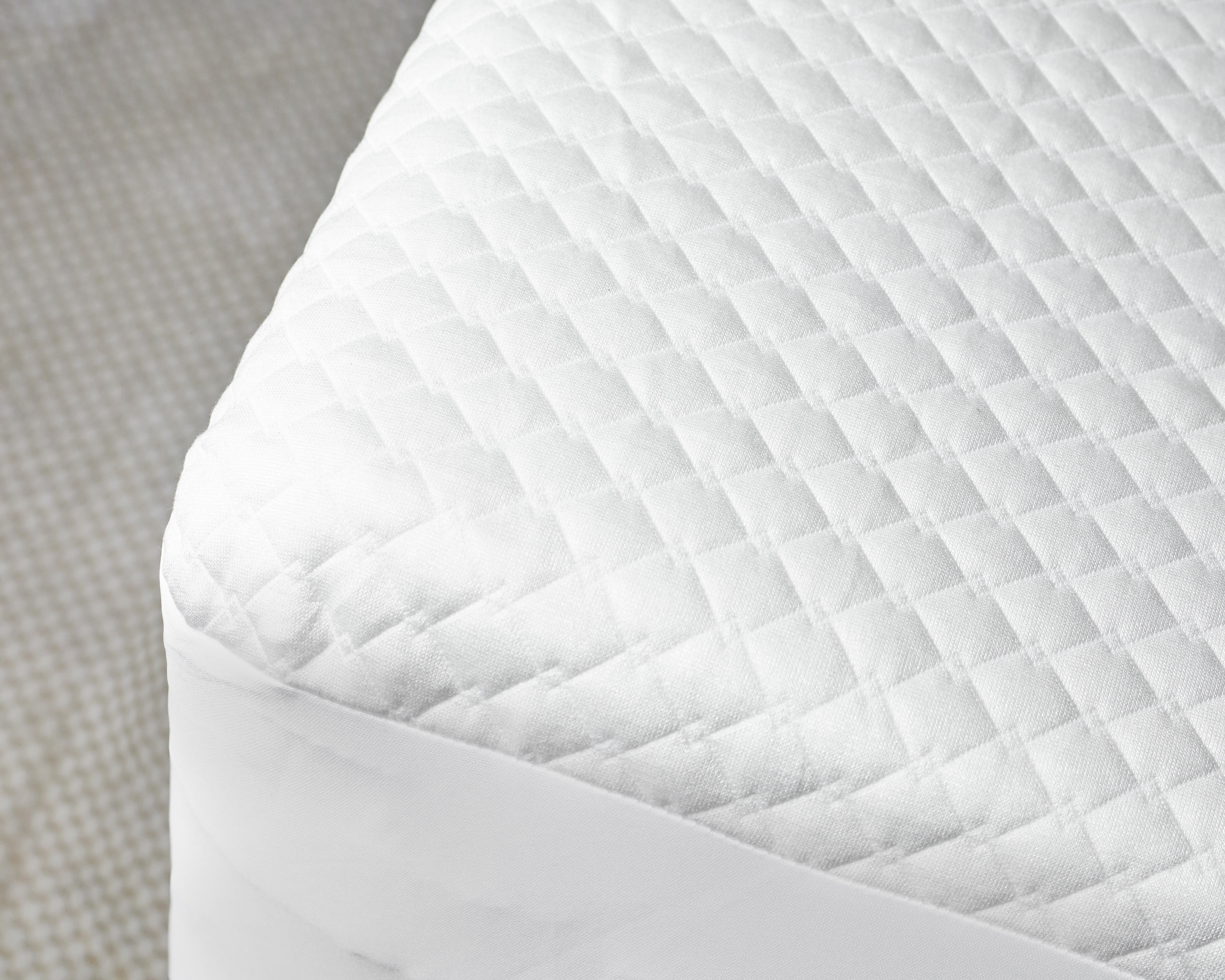 Quilted white waterproof mattress protector made with cotton fabric for allergy and bed bug protection.