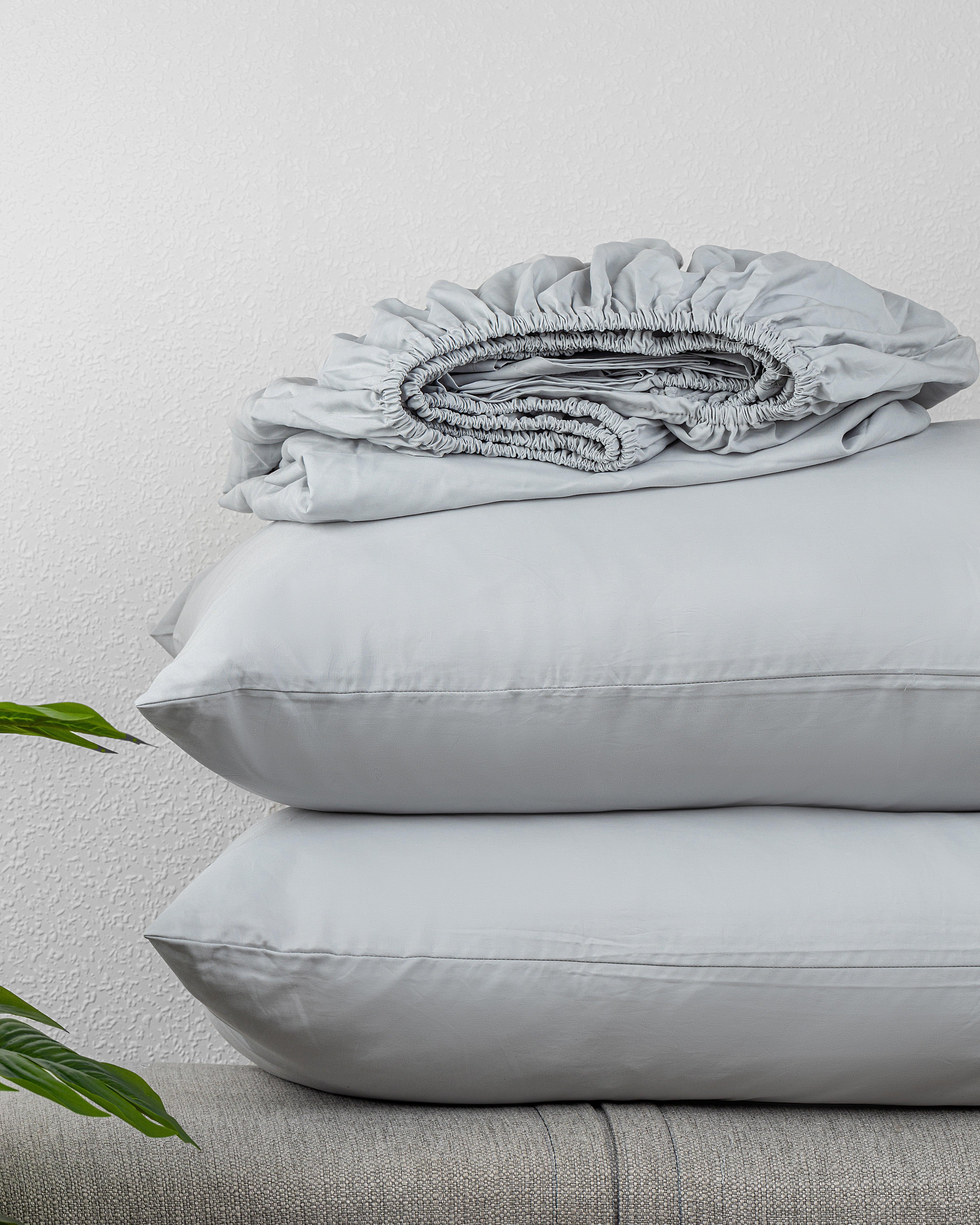 Regal Collection Fitted Sheet Set in soft, high-quality cotton stacked with pillows.