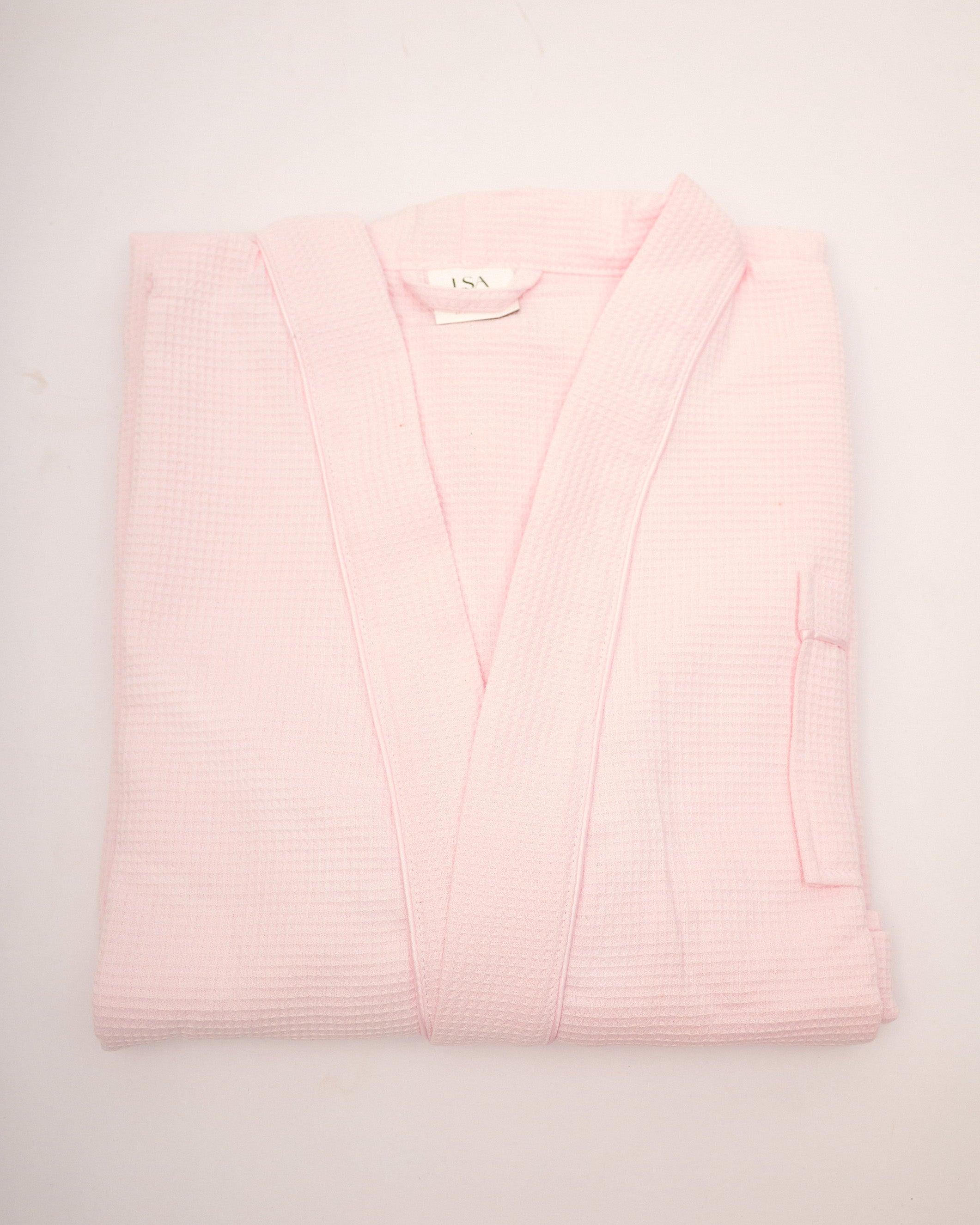 Folded pink piped waffle bathrobe with soft textured fabric for spa and home relaxation
