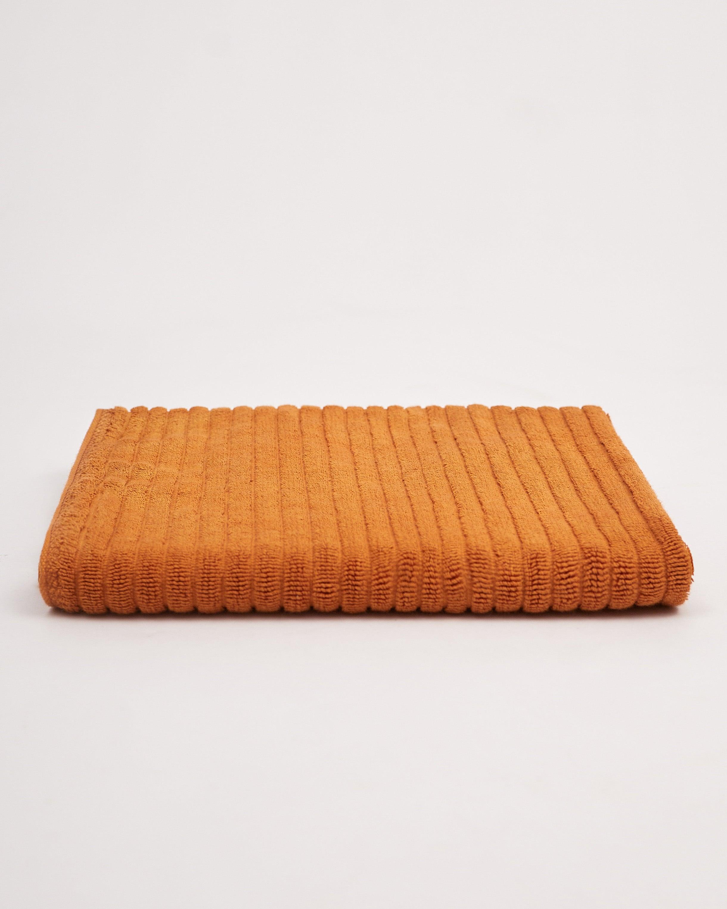 Linea Towel Collection in orange, folded neatly.