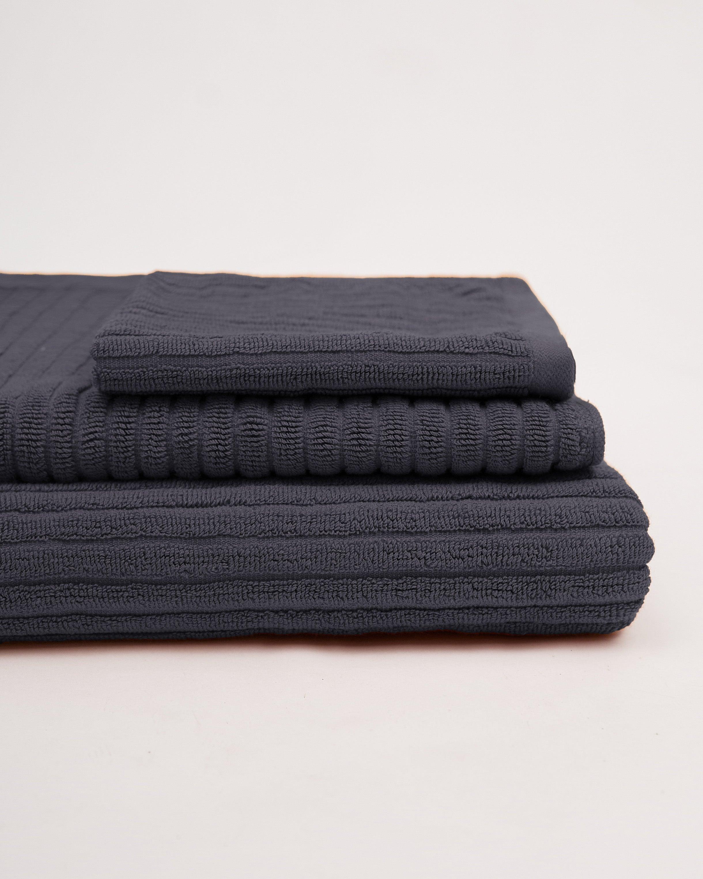 Linea Towel Collection stacked in black, soft plush material.