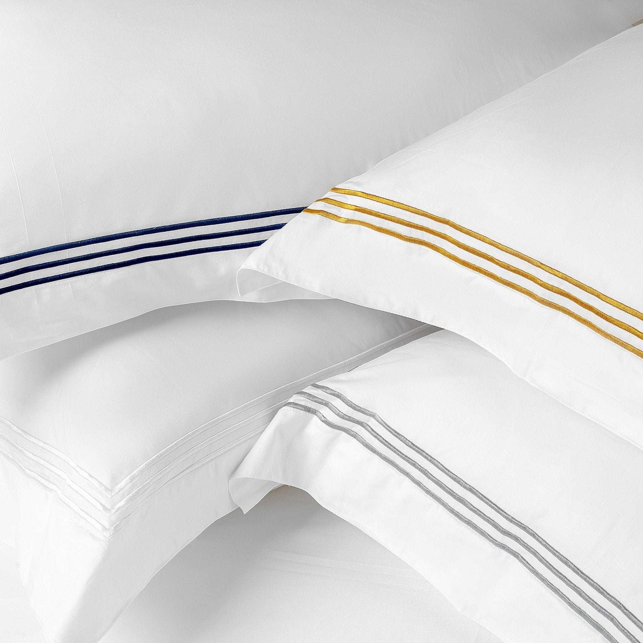 Lanes Luxury White 6pc Set white bedding with elegant embroidered pillowcases in blue, gold, and silver stripes