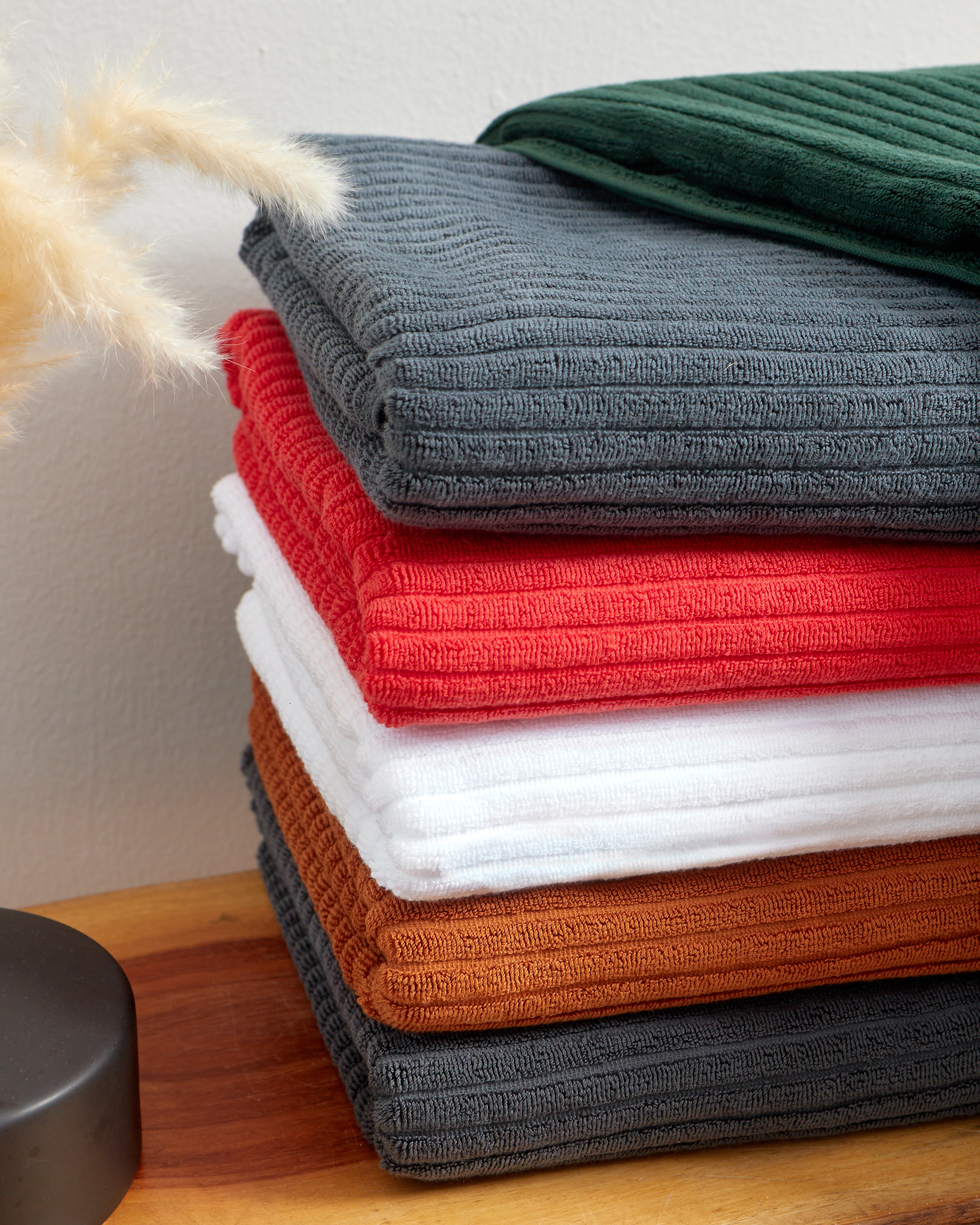 Linea Towel Collection in assorted colors, soft cotton towels stacked neatly for a luxury bath experience.