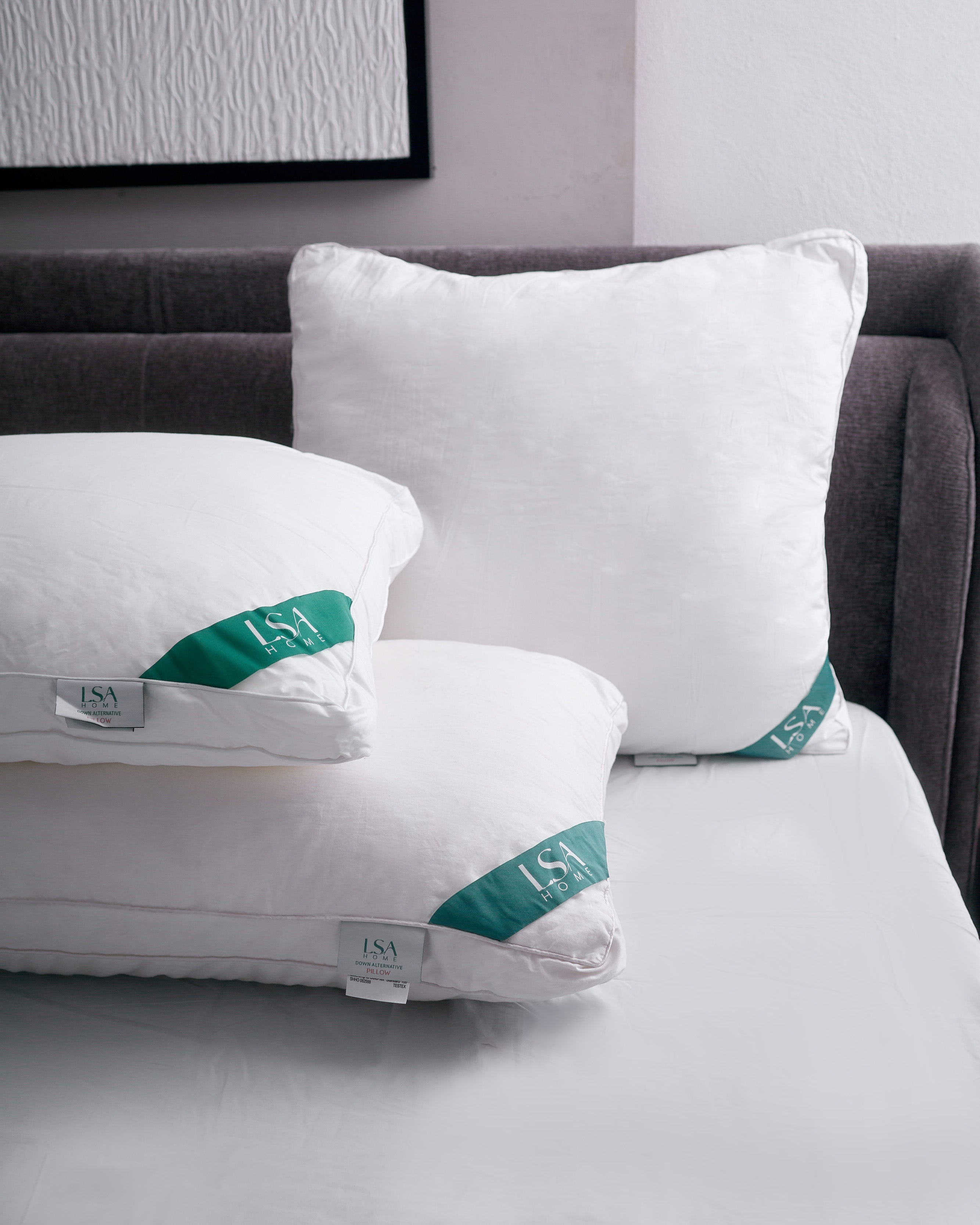 Pair of white down alternative pillows with hypoallergenic hollow fiber filling on a bed