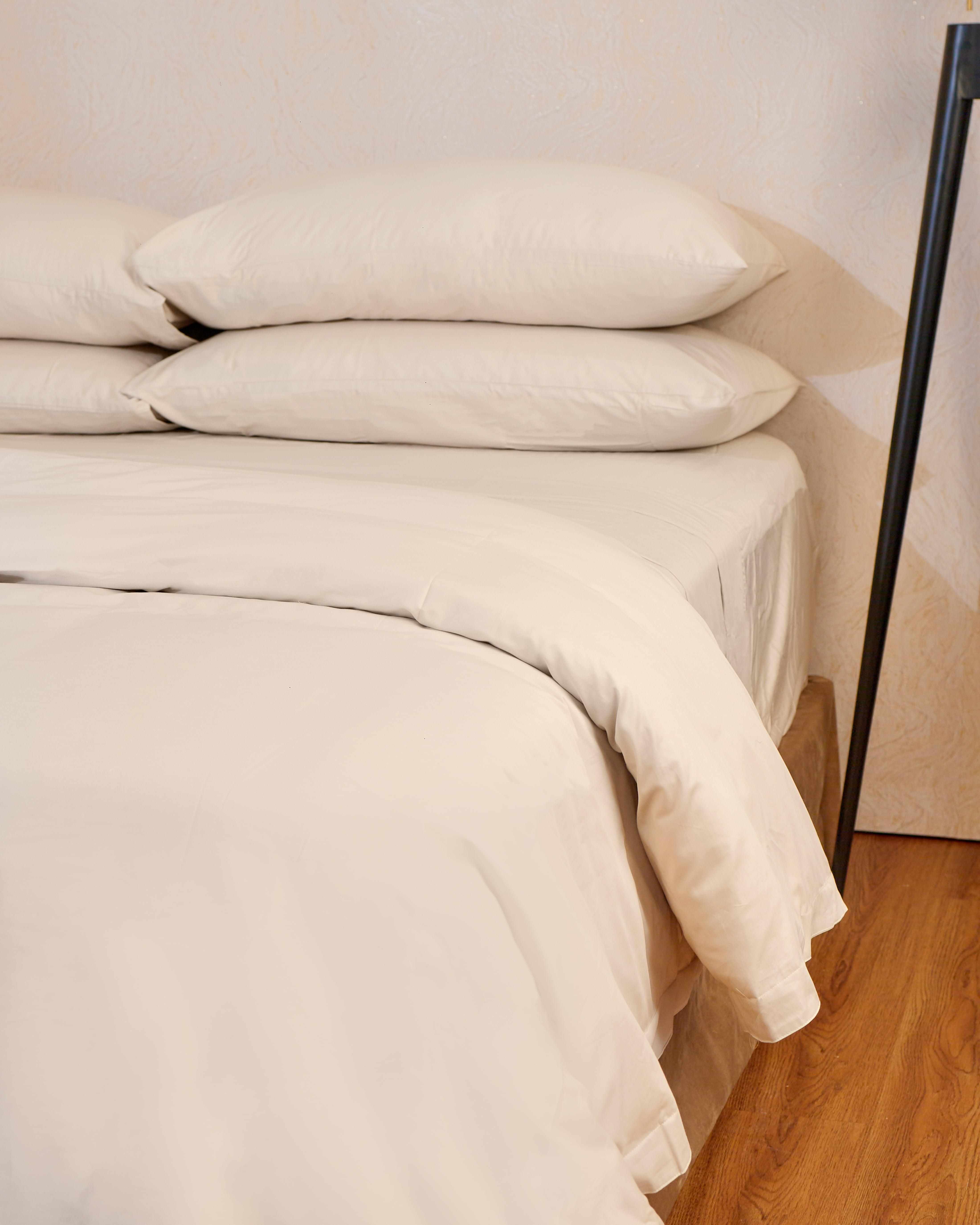 Linen Luxe Sheet Set on a bed with pillows, featuring a luxurious and timeless design.